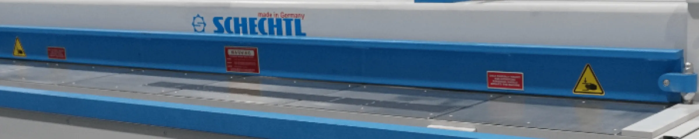 Close-up of a Schechtl metal shear machine used for precise cutting.